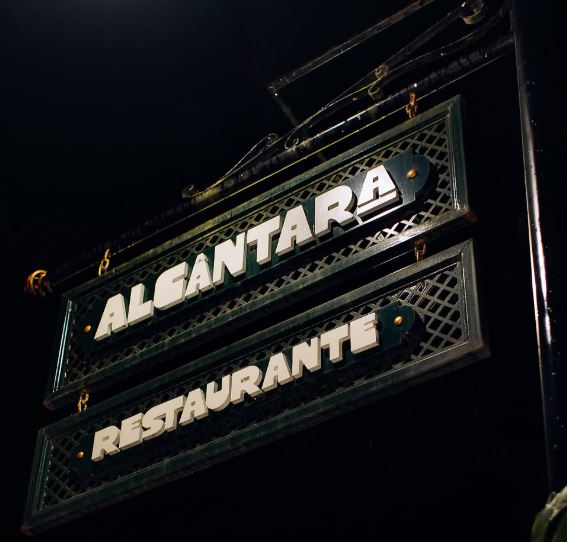 Placa do Alcântara Restaurante iluminada à noite